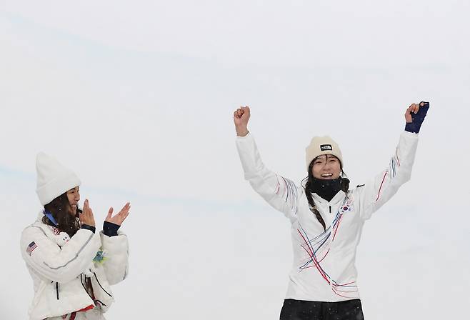 12일(현지시간) 이탈리아 리비뇨 스노파크에서 열린 2026 밀라노-코르티나담페초 동계올림픽 스노보드 여자 하프파이프 결승에서 금메달을 따낸 최가온이 시상대에 오르며 기뻐하고 있다. 왼쪽은 은메달을 딴 미국 클로이 김. 연합뉴스