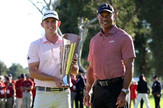 제이컵 브리지먼이 PGA 투어 시그니처 대회 제네시스 인비테이셔널 주최자인 타이거 우즈로부터 우승 트로피를 전달받은 뒤 함께 기념촬영하고 있다. (사진=AFPBBNews)