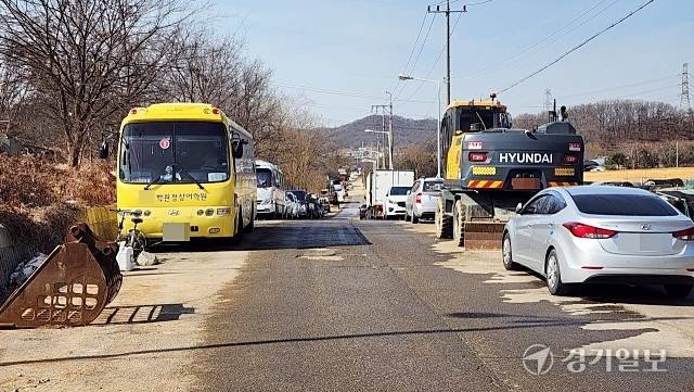 광명시 노온사동 밤일로 왕복2차선 도로 양쪽 끝에 버스와 중장비 등이 주차돼 있다. 한준호기자