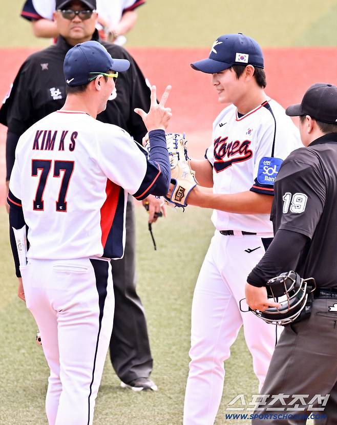 24일 일본 오키나와 가데나 구장에서 열린 야구 대표팀과 KIA 타이거즈의 평가전. 5회초 1사 KIA 데일 강습 타구를 막아낸 김택연이 김광삼 코치와 상태를 체크하고 있다. 오키나와(일본)=박재만 기자 pjm@sportschosun.com/2026.02.24/