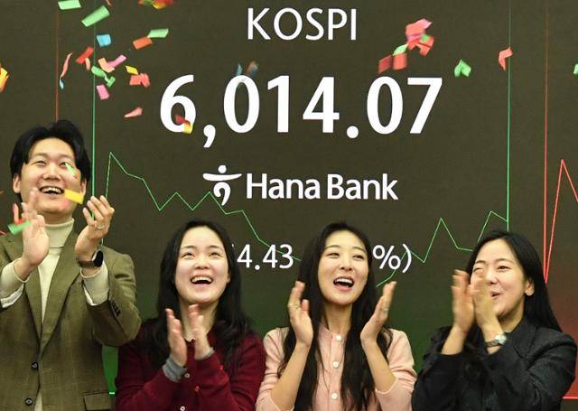 코스피 지수가 장 시작과 함께 6000포인트를 돌파한 25일 서울 중구 하나은행 본점 딜링룸 전광판 앞에서 직원들이 기뻐하고 있다. 윤기훈 인턴기자