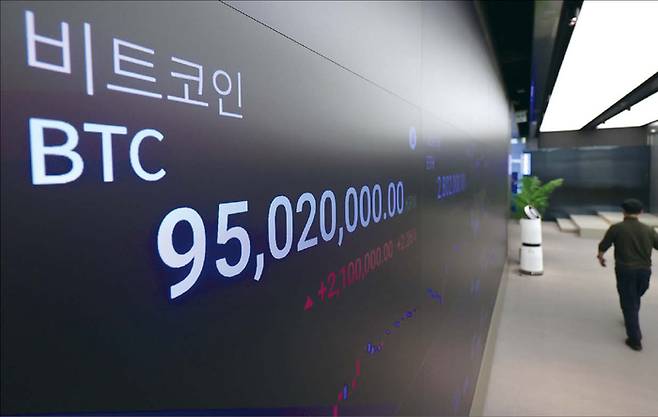 비트코인이 급락하며 1억원대가 깨진 지난 2월 6일 서울 강남구 업비트 고객센터 전광판에 비트코인 등 암호화폐 시세가 나오고 있다. (뉴시스)