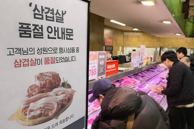 삼겹살 파격가에 품절 행렬 - 지난해 ‘삼겹살데이’인 3월 3일 서울의 한 이마트 매장에 돼지고기를 사러온 손님들의 오픈 런이 이어지면서 삼겹살·목심 할인 행사 종료를 알리는 안내문이 붙어 있다. 뉴스1