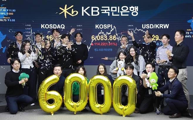 KB국민은행 직원들이 지난 25일 딜링룸에서 코스피 지수 6000선 돌파를 기념하고 있다. 사진=KB국민은행 제공