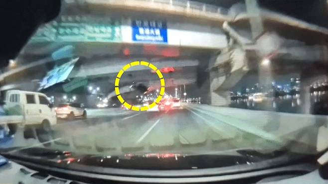 지난달 25일 오후 8시44분 서울 반포대교를 달리던 포르쉐 차량이 다리 밑 한강 둔치로 추락하는 모습. 연합뉴스