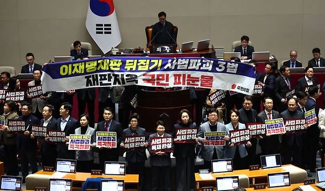 국민의힘 의원들이 지난달 27일 국회 본회의에서 '사법개혁 3법 반대' 관련 구호가 적힌 현수막과 피켓을 들고 항의하고 있다.ⓒ뉴시스