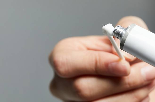 면봉에 연고를 묻혀 사용하는 모습. 손가락 대신 멸균 면봉을 사용하면 필요한 만큼만 덜어 위생적으로 바를 수 있다. 사진=게티이미지뱅크