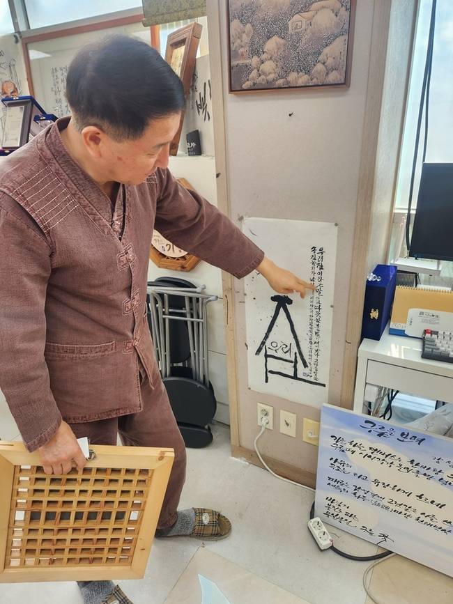 ▲ 강성태 서예가가 '우리집' 작품을 가리키며 의미를 설명하고 있다. 서의수 기자