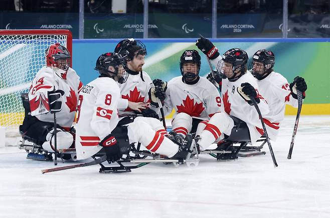 캐나다 선수들이 9일(현지시간) 이탈리아 밀라노 산타줄리아 아이스하키 아레나에서 열린 2026 밀라노·코르티나담페초 동계패럴림픽 장애인 아이스하키 예선 B조 일본과의 경기에서 승리를 거둔 뒤 기뻐하고 있다. 로이터