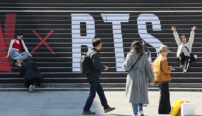 방탄소년단의 컴백 라이브 공연을 일주일여 앞둔 13일 서울 종로구 세종문화회관 계단에 마련된 방탄소년단 공연 홍보물 앞에서 외국인 관광객들이 기념촬영을 하고 있다.