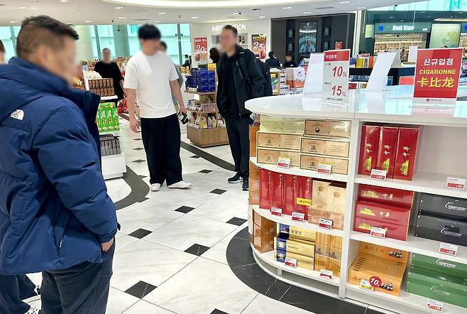 ▲ 지난달 22일 오전 10시30분쯤 인천국제공항 제2여객터미널 면세점에서 한 중국인이 중국산 수입 담배가 진열된 매대를 살펴보고 있다. /변성원 기자 bsw906@incheonilbo.com