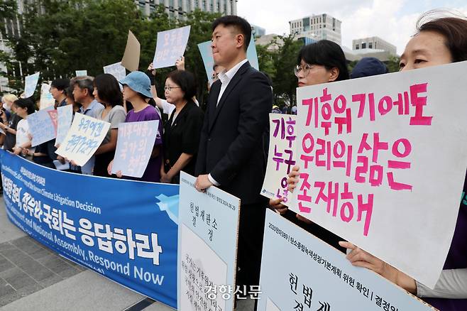 청소년·시민·아기기후소송과 탄소중립기본계획소송 청구인단 및 변호인단 소속 한 활동가가 지난해 8월 27일 서울 광화문 이순신 동상 앞에서 “헌법이 보장한 권리, 정부와 국회는 응답하라”며 기후 헌법소원 결정 1주년 기자회견을 하고 있다. 정지윤 선임기자