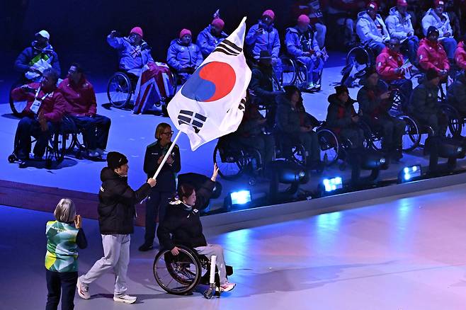 휠체어컬링 백혜진과 스노보드 이제혁이 15일(현지시간) 이탈리아 코르티나담페초 컬링 올림픽 스타디움에서 열린 2026 밀라노 코르티나 패럴림픽 폐막식에서 태극기를 들고 입장하고 있다. 2026.3.16 ⓒ 뉴스1 사진공동취재단