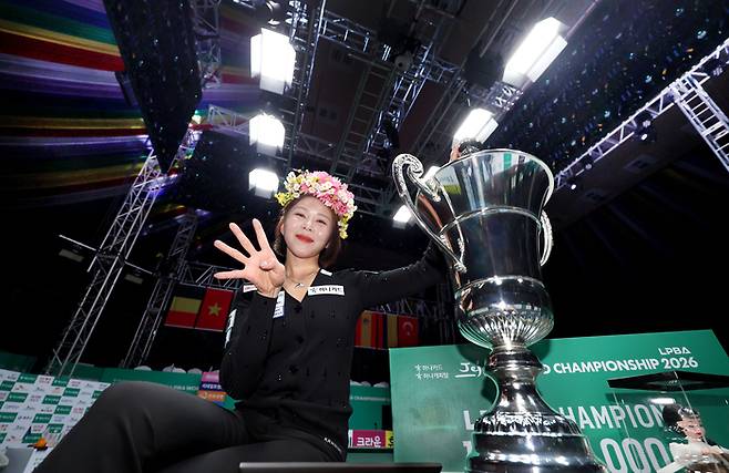 김가영이 14일 제주 한라체육관에서 열린 2025~2026시즌 ‘하나카드 하나캐피탈 제주특별자치도 월드챔피언십’ LPBA 결승전에서 대회 통산 네 번째 우승에 성공한 뒤 손가락 네 개를 꺼내들며 트로피 앞에서 포즈하고 있다. 사진 | 프로당구협회