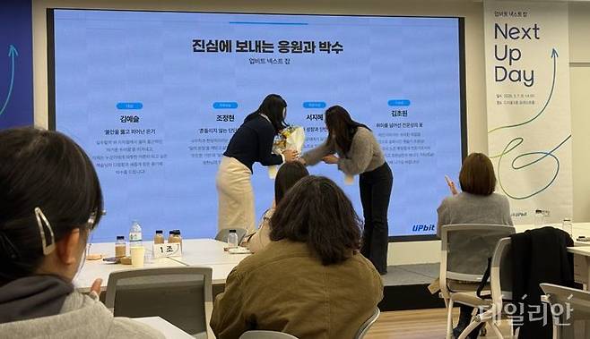 이수민 두나무 임팩트 비즈니스실 실장이 지난 7일 서울 강남구 드리움에서 열린 업비트 넥스트 잡 홈커밍데이에서 김예슬 자립준비청년에게 축하의 꽃다발을 건네며 격려하고 있다.ⓒ데일리안 황지현 기자