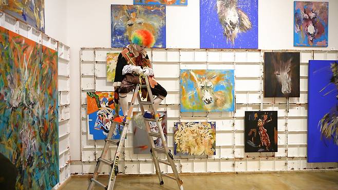 박신양의 ‘당나귀’ 연작과 그 앞에 앉아 있는 배우의 모습. 민음사 제공