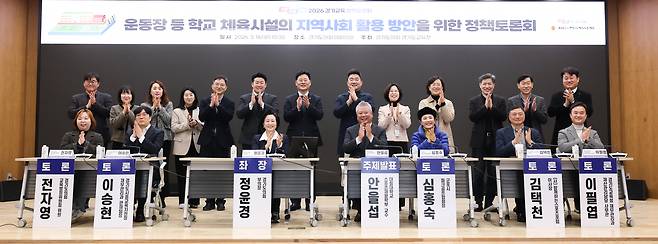 운동장 등 학교 체육시설의 지역사회 활용 방안을 위한 정책토론회에 참석한 인사들이 박수하며 기념 사진을 찍고 있다.