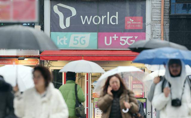 2025년 12월 서울 시내 한 휴대폰 매장 앞을 시민들이 지나가고 있다. 뉴스1