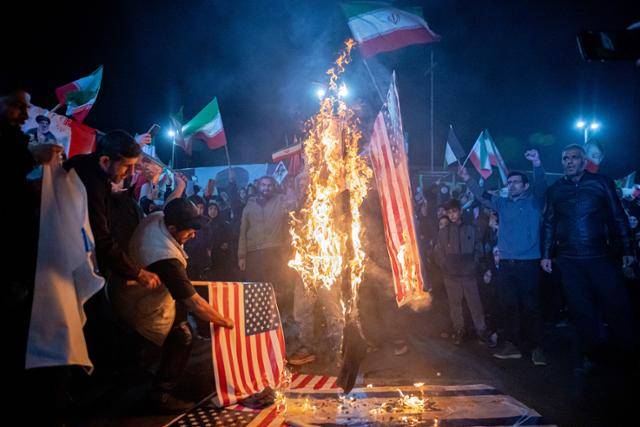 17일 이란 수도 테헤란에서 시위대가 이스라엘과 미국 국기를 불태우며 공격을 규탄하고 있다. 테헤란=UPI 연합뉴스
