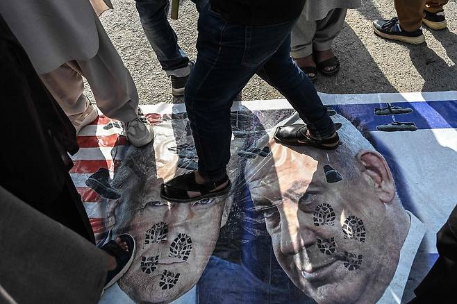 지난 6일 이슬라마바드에서 열린 반미·반이스라엘 시위 현장에서 시아파 무슬림들이 도널드 트럼프 미국 대통령(왼쪽)과 베냐민 네타냐후 이스라엘 총리의 포스터를 짓밟고 있다. AFP=연합뉴스