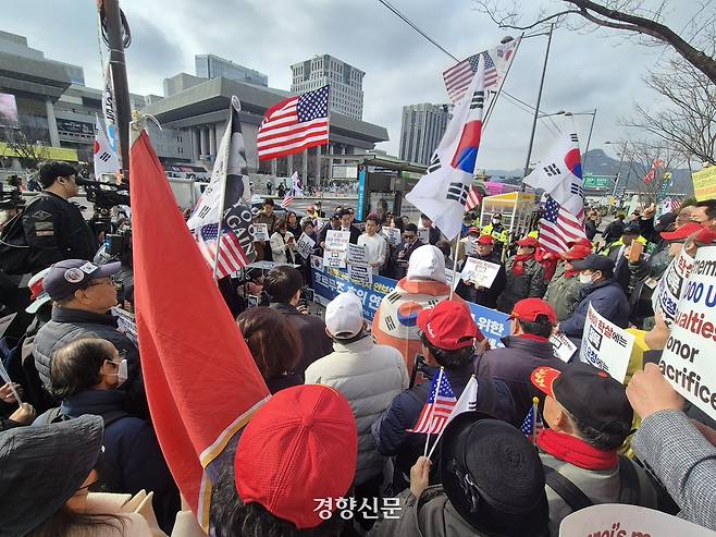 극우 성향 유튜버 전한길씨가 18일 서울 종로구 미국대사관 인근에서 주최한 ‘호르무즈 호위 연합 결단 촉구 기자회견’에 참석한 지지자들이 전씨 등의 발언을 지켜보고 있다. 김태욱 기자