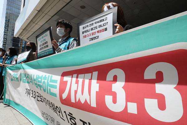 지난 2021년 5월 12일 서울 중구 서울지방고용노동청 앞에서 권리찾기유니온 주최로 열린 '가짜 3.3 근로자지위확인 1호 진정 접수' 기자회견에서 참석자들이 손팻말을 들고 있다. 연합뉴스