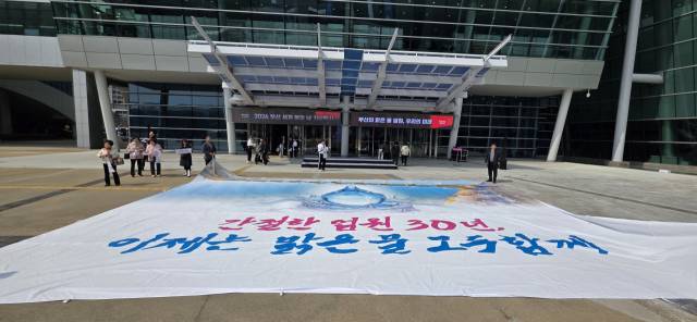 맑은 물을 향한 부산시민의 30년 염원이 담긴 대형 현수막이 19일 오후 벡스코 컨벤션홀 앞 광장에 펼쳐졌다. 오금아 기자