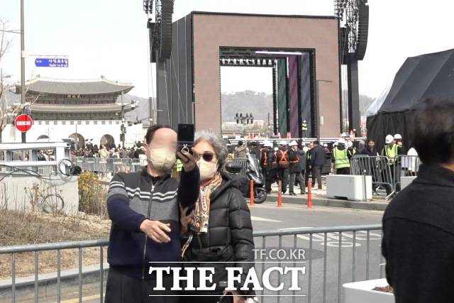 방탄소년단(BTS) 컴백 공연을 하루 앞둔 20일, 서울 광화문광장과 세종대로를 배경으로 시민들이 인증사진을 남기고 있다. /광화문=김민지 기자