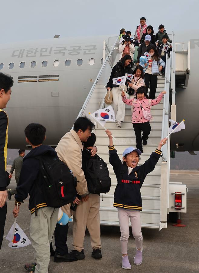 미국·이란 전쟁으로 중동 정세가 최악으로 치닫는 가운데 사우디아라비아 리야드에서 우리 공군 KC-330 ‘시그너스’ 수송기를 타고 15일 성남 서울공항을 통해 귀국한 중동 거주 교민들이 태극기를 흔들며 비행기에서 내리고 있다. 시그너스에는 우리 국민 204명을 비롯해 일본인 2명 등 211명이 탑승했다. 성남=사진공동취재단