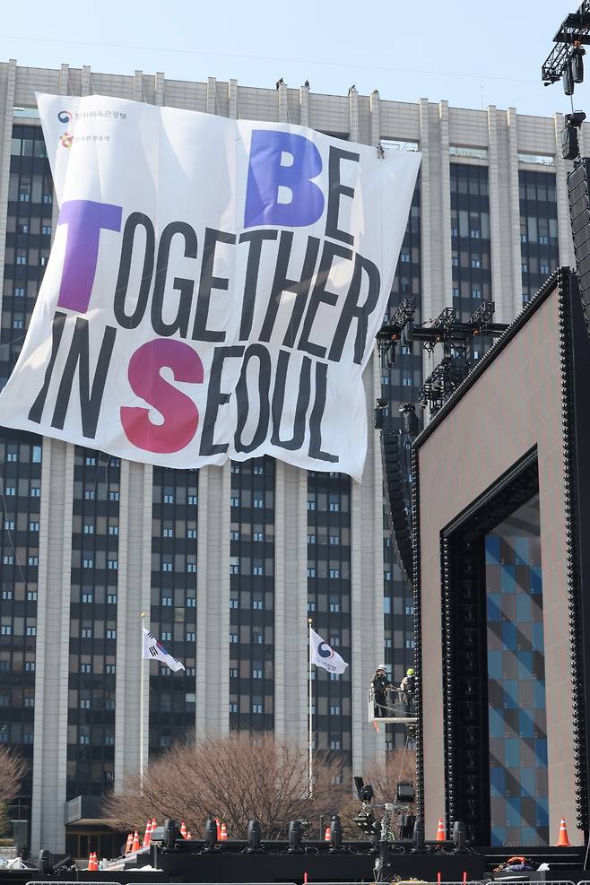 그룹 방탄소년단(BTS)의 광화문 공연을 앞둔 20일 공연장 부근 정부서울청사에서 관계자들이 대형 현수막을 설치하고 있다. <연합뉴스>