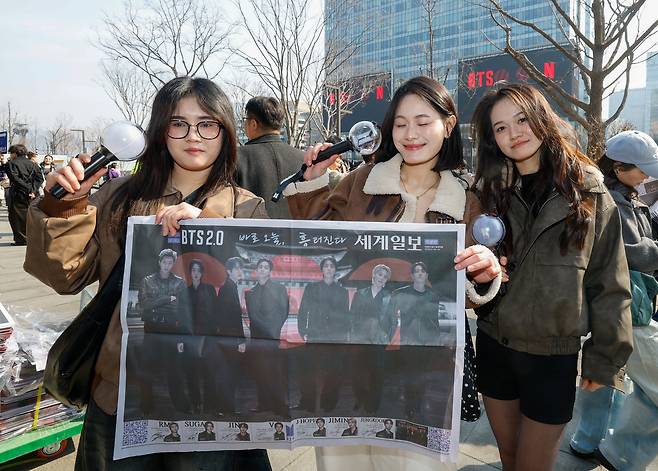 방탄소년단(BTS) 광화문 컴백 공연이 펼쳐지는 21일 서울 종로구 광화문 광장에서 외국인 아미(BTS 팬덤 명칭)들이 세계일보 특별판 지면을 들고 기념사진을 찍고 있다.