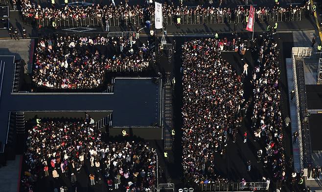 BTS 팬들이 21일 서울 종로구 광화문광장에서 열리는 BTS 컴백 공연을 관람하기 위해 관객석으로 입장하고 있다. 뉴시스