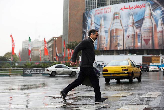 16일(현지시간) 이란 테헤란에서 이란 미사일 이미지가 담긴 대형 광고판 옆을 한 남성이 지나가고 있다. 2026. 03. 16. ⓒ 로이터=뉴스1