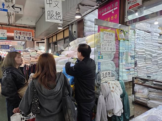 지난 19일 오후 서울 종로구 광장시장의 한 침구 매장에서 외국인 관광객들이 이불을 고르고 있다./권유정 기자