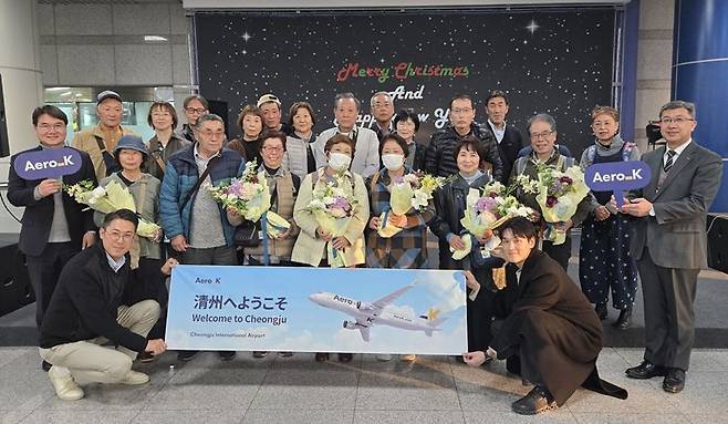 에어로케이항공을 타고 20일 청주공항에 입국한 일본 관광객들과 관계자들이 기념촬영을 하고 있다. 에어로케이항공 제공