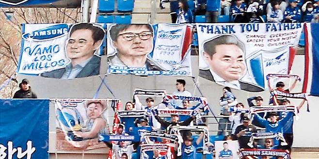 과감한 투자 바라는 팬들 “가자, 백만장자여” 수원 삼성 팬이 내건 이재용(왼쪽부터) 삼성전자 회장과 이정효 감독, 고(故) 이건희 선대회장 배너. 이건희 회장 걸개엔 ‘고맙습니다, 아버지’란 문구 아래 ‘마누라와 자식 빼고 다 바꿔라’는 ‘신경영 선언’이 영어로 적혀 있다. 이재용 회장 배너에는 아르헨티나 리버 플레이트 응원 구호인 ‘Vamo Los Millos(가자, 백만장자들)’를 썼는데, 구단에 과감한 투자를 바라는 팬들의 염원이 담겼다. /프로축구연맹