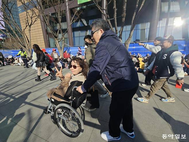 21일 아내 최희욱 씨(64)와 남편 이기상 씨(69)가 안내요원과 시민들의 도움을 받아 BTS 공연장으로 이동하고 있다. 정동진 기자