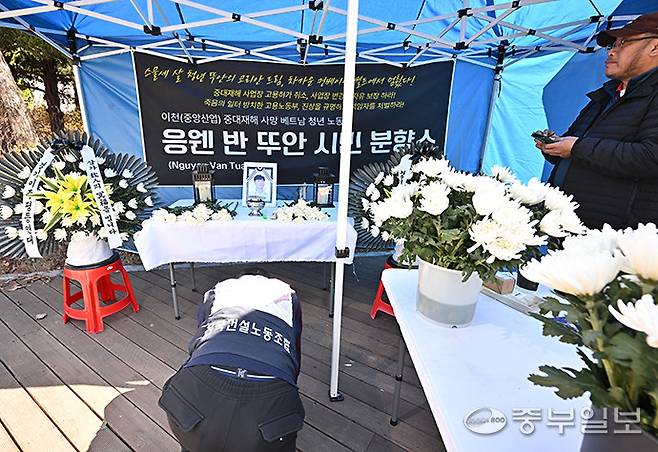 19일 오전 수원시 경기지방고용노동청 앞에서 한 시민이 이천 자갈 가공업체에서 일하다 사망한 베트남 국적 23살 이주노동자 응웬 반 뚜안씨의 시민분향소에 헌화를 하고 절을 올리고 있다. 김경민기자