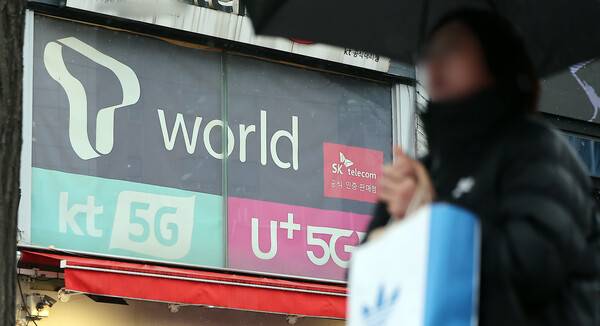 2025년 12월 23일 오후 서울의 한 휴대폰 매장 앞으로 시민이 지나가고 있다. / 뉴스1