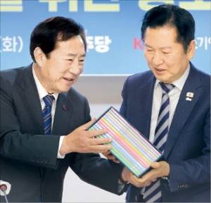 김기문 중기중앙회장(왼쪽)이 24일 중소기업 간담회에서 정청래 더불어민주당 대표에게 지방 중소기업 성장전략 제안서를 전달하고 있다. 연합뉴스