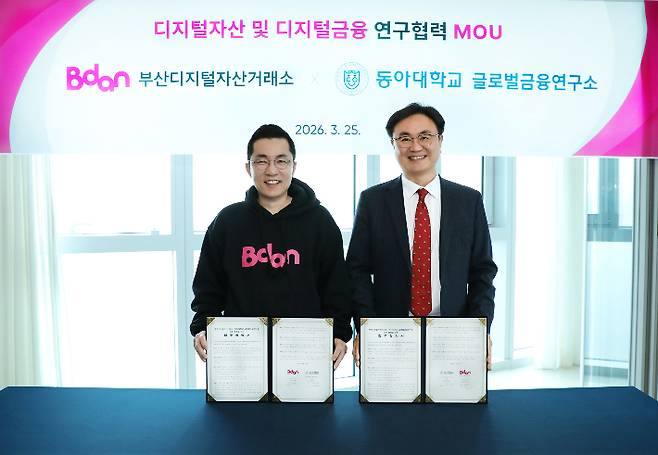 김상민 부산디지털자산거래소(Bdan) 대표(왼쪽)와 조용복 동아대 글로벌금융연구소 소장이 25일 부산디지털자산거래소 본사에서 업무협약을 체결하고 있다. 비단 제공