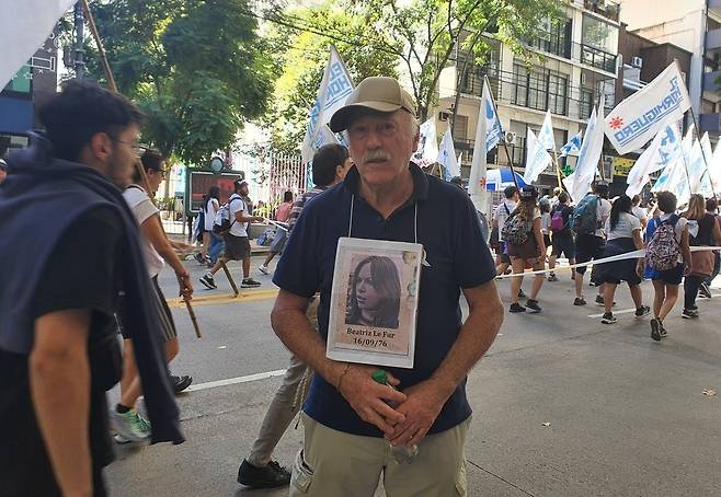 아르헨 군사 쿠데타 50주년 행진에서 인터뷰하는 산티아고 카라라(77)씨 (부에노스아이레스=연합뉴스) 김선정 통신원 = 아르헨티나의 수도 부에노스아이레스에서 1976년 군사 쿠데타 50주년 기념 행진을 하던 산티아고 카라라(77) 씨가 연합뉴스와 인터뷰를 하고 있다. 당시 20세의 아내 베아트리스 씨가 군사 독재 정권에 의해 불법 구금된 후 실종되었으며, 그는 그녀의 사진을 목에 맨 채 해마다 이날 그녀를 추모하며 가족들과 함께 행진한다고 말했다. 2026.3.25 sunniek8@yna.co.kr