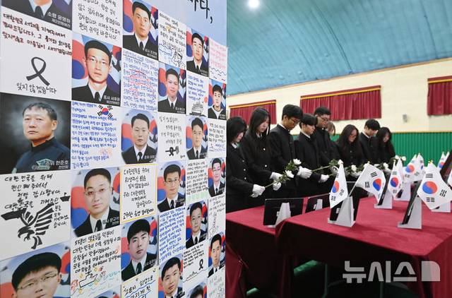 제11회 서해수호의 날을 이틀 앞둔 지난 25일 천안함 피격 전사자 고(故) 박경수 상사의 모교인 경기 수원시 삼일공업고등학교에서 열린 추모식에서 학생들이 헌화하고 있다. 뉴시스 제공