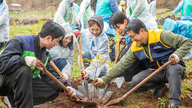 환경 보호 활동 참여자들이 함께 나무를 심고 있는 모습/사진=진에어