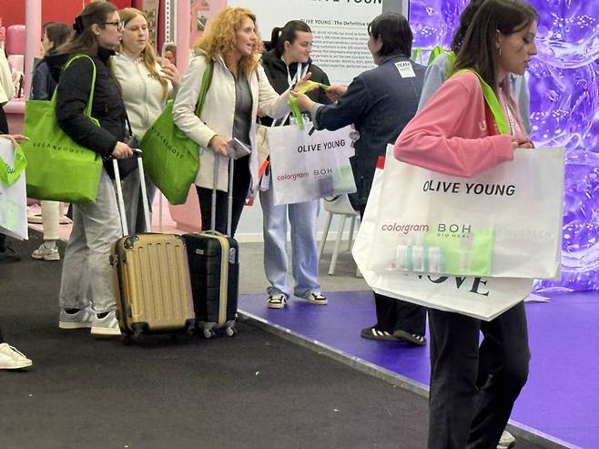 코스모프로프 볼로냐 2026에 참석한 바이어들이 올리브영 구디백을 들고 있다. (사진=최수진 기자)