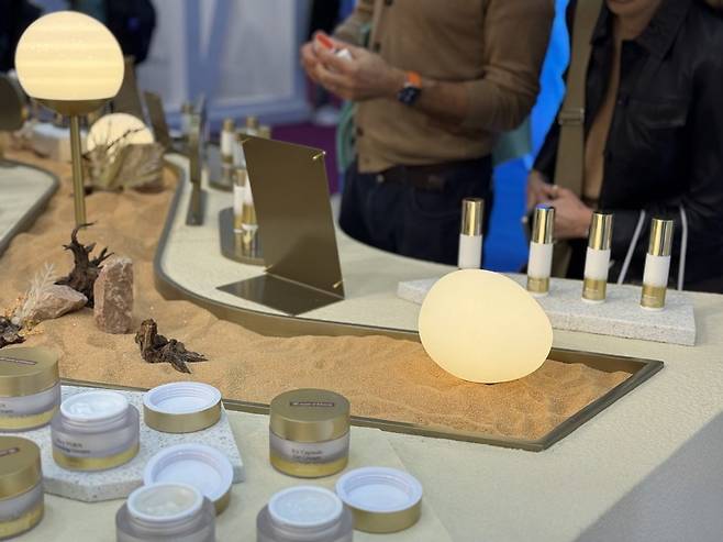 방문객들이 사막에서 부는 바람을 형상화한 한국콜마 부스에서 제품을 체험하고 있다. (사진=최수진 기자)