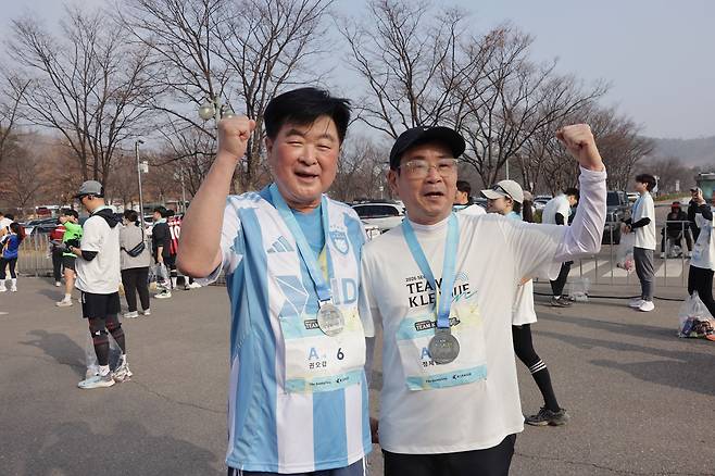 서울 상암동 월드컵공원 평화광장 일대에서 열린 2026 서울 팀 K리그 행사에서 10km를 완주한 뒤 기념 메달을 목에 걸고 포즈를 취한 권오갑 한국프로축구연맹 총재(왼쪽)와 정제원 중앙일보S 대표이사. 사진 프로축구연맹