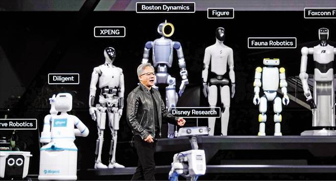 < ‘아틀라스’ 앞에서 연설 젠슨 황 > 엔비디아 최고경영자(CEO)가 지난 16일(현지시간) 미국 새너제이에서 열린 ‘GTC 2026’에서 보스턴다이내믹스의 ‘아틀라스’ 등 휴머노이드 로봇들을 선보이며 피지컬 인공지능(AI)에 대해 발표하고 있다. AP연합뉴스