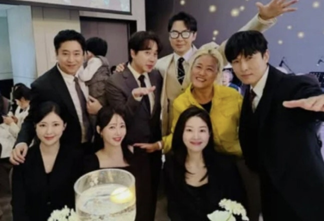 신화 이민우의 결혼식에서 만나 포즈를 취한 신화의 멤버, 배우자들과 사진작가 조선희. 사진 조선희 SNS 캡쳐