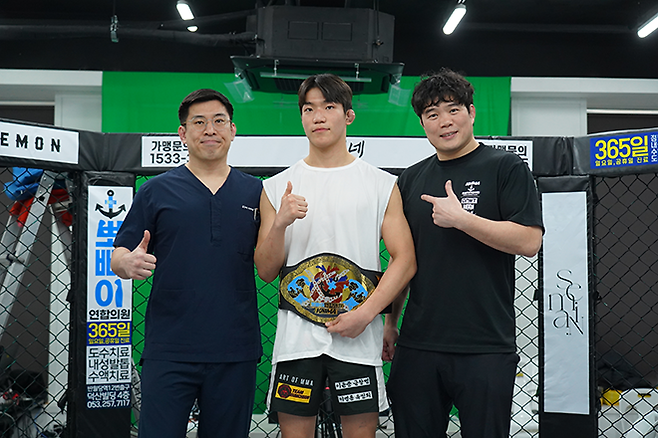 KMMA 페더급 챔피언을 지낸 김지경이 로드FC 2연승 등 프로 3승 무패 활약을 인정받아 KMMA 명예의 전당에 헌액됐다. 김대환 KMMA 공동대표와 메인스폰서 뽀빠이연합의원 김성배 대표원장이 기념 벨트를 시상했다. 사진=뽀빠이연합의원KMMA파이터에이전시 제공